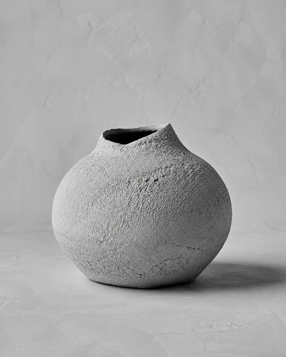 Illustrative monochrome image: Artisan textured ceramic vase for floral arrangements